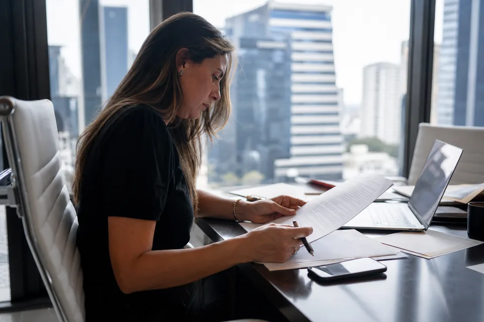 Founder reviewing a software contract and pricing sheet at a desk